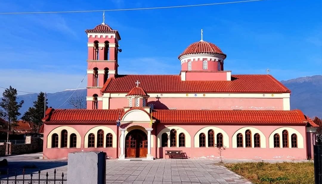 Pink Byzantine church with dome and bell tower in village near Lake Kerkini, Greece